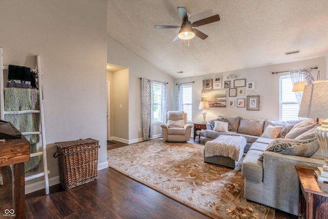 living room featuring lofted ceiling, wood finished floors, a textured ceiling, visible vents, and a ceiling fan