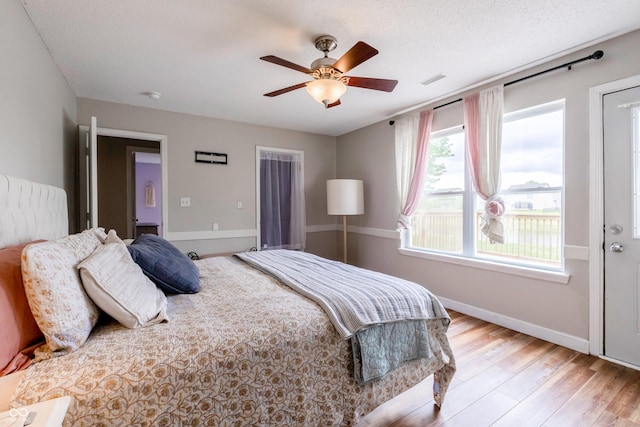 bedroom featuring ceiling fan, baseboards, visible vents, and wood finished floors