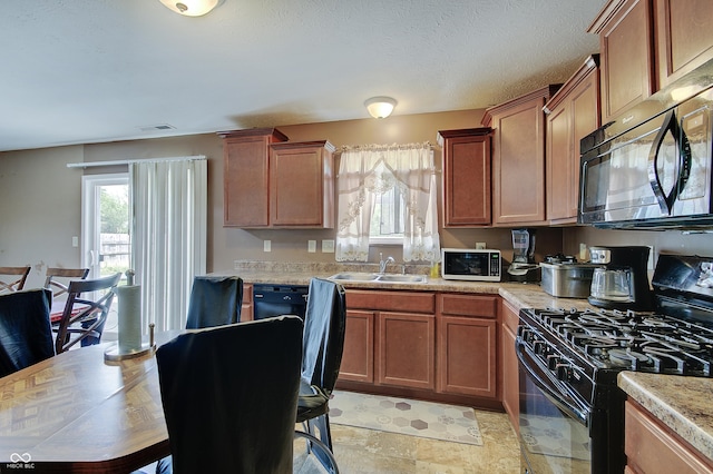 7303 Beal Ln, Indianapolis, IN 46217 - kitchen featuring black appliances, a sink, light countertops, light stone finish flooring, and brown cabinets