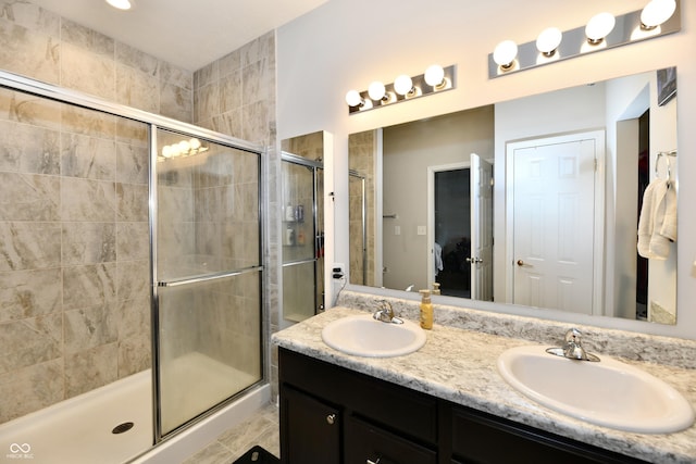 ensuite bathroom featuring a sink, a shower stall, double vanity, and connected bathroom