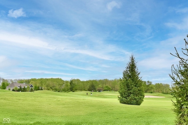 view of home's community with golf course view and a yard