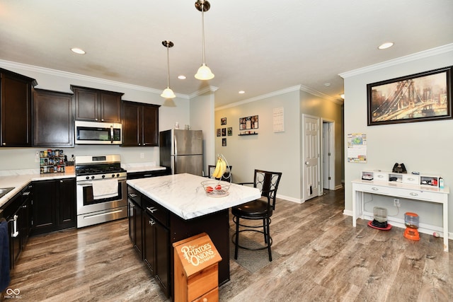 kitchen with recessed lighting, appliances with stainless steel finishes, a kitchen island, and a breakfast bar area