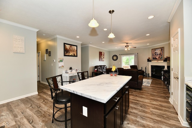 kitchen featuring a ceiling fan, pendant lighting, dark wood-style floors, a breakfast bar, and recessed lighting
