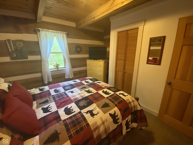 carpeted bedroom featuring a closet, baseboards, beam ceiling, and wooden ceiling