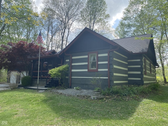 view of property exterior featuring a shingled roof, a yard, and log siding