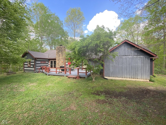 view of yard with a detached garage, an outdoor structure, and a deck