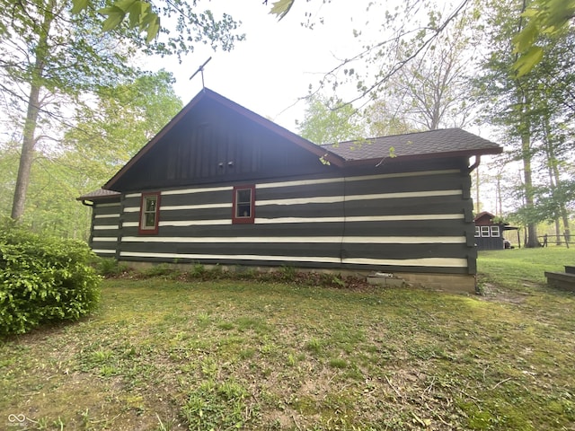 view of side of property with log siding and a yard