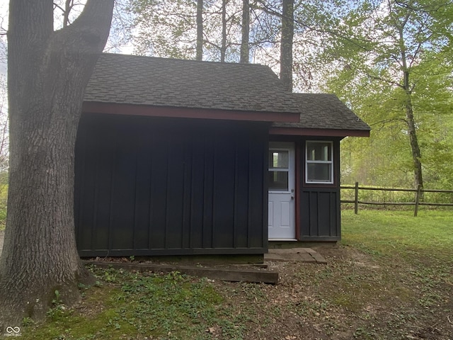 view of outdoor structure featuring fence and an outbuilding