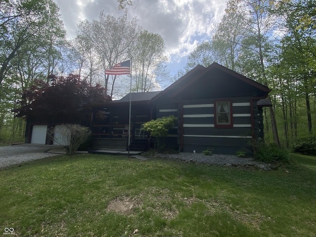 view of front facade featuring log exterior, a front yard, and a garage