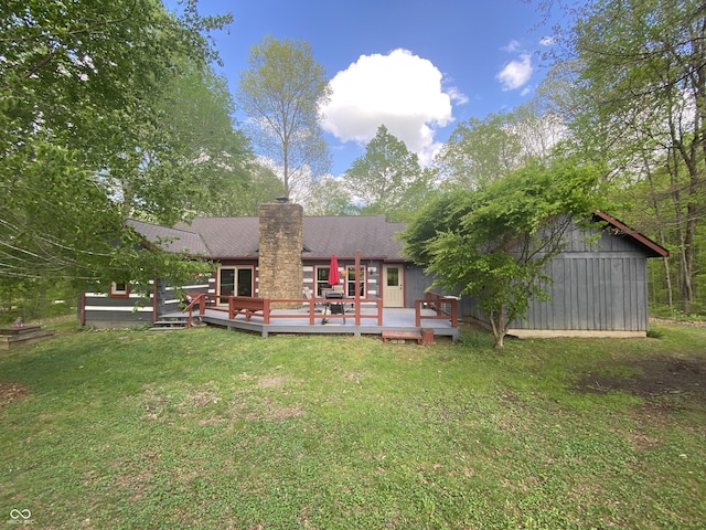 rear view of house featuring a lawn, a shingled roof, a chimney, and a deck