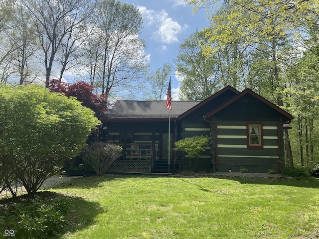 back of house featuring covered porch, log siding, and a yard