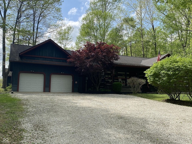 view of front of property featuring a shingled roof, an attached garage, and driveway