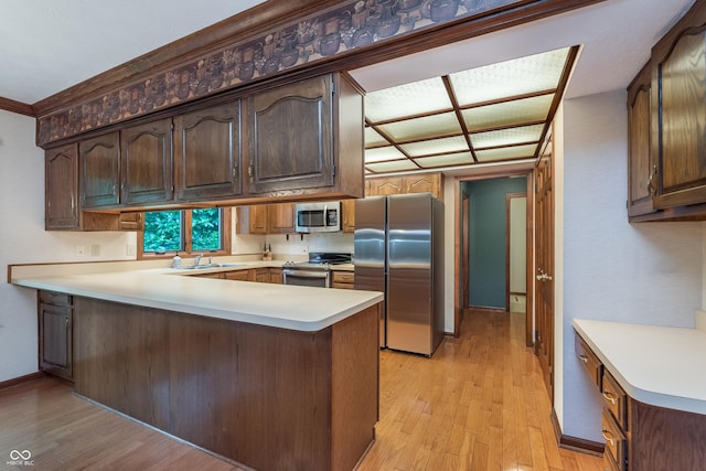 1421 Stoney Creek Cir, Carmel, IN 46032 - kitchen featuring stainless steel appliances, a peninsula, light wood finished floors, and light countertops