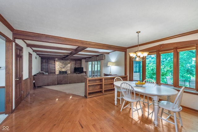 1421 Stoney Creek Cir, Carmel, IN 46032 - dining space featuring light wood-type flooring, a stone fireplace, a chandelier, and beam ceiling