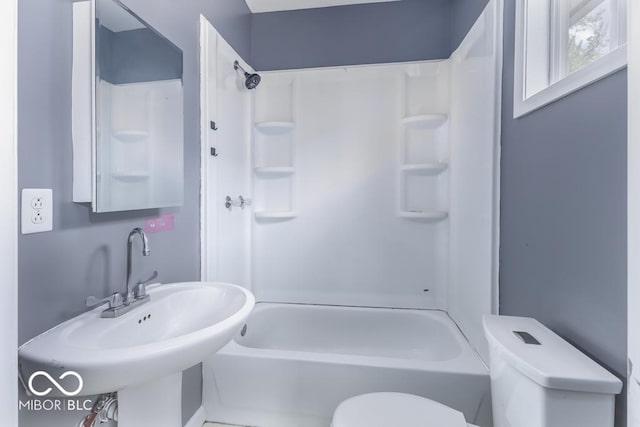 bathroom with a sink, shower / bathtub combination, and toilet