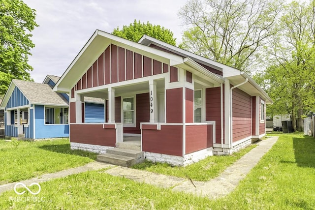 exterior space with board and batten siding, a porch, and a front yard