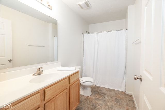full bathroom featuring vanity, visible vents, toilet, a shower with curtain, and stone finish flooring
