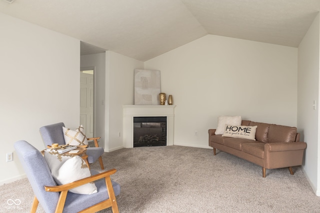 carpeted living area with a glass covered fireplace and lofted ceiling