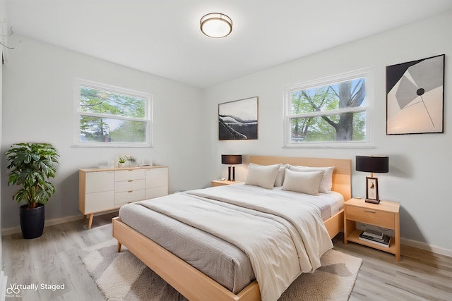 1116 Heatherwood Dr, Indianapolis, IN 46241 - bedroom with baseboards, multiple windows, and light wood-type flooring