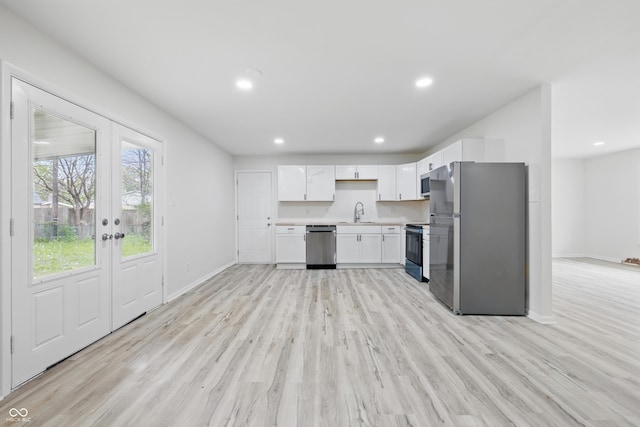 1116 Heatherwood Dr, Indianapolis, IN 46241 - kitchen featuring appliances with stainless steel finishes, white cabinets, baseboards, and light wood-type flooring