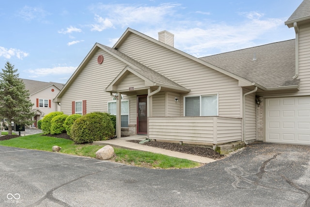 3006 Wildcat Ln, Indianapolis, IN 46203 - view of front of property with a chimney, aphalt driveway, a shingled roof, and an attached garage