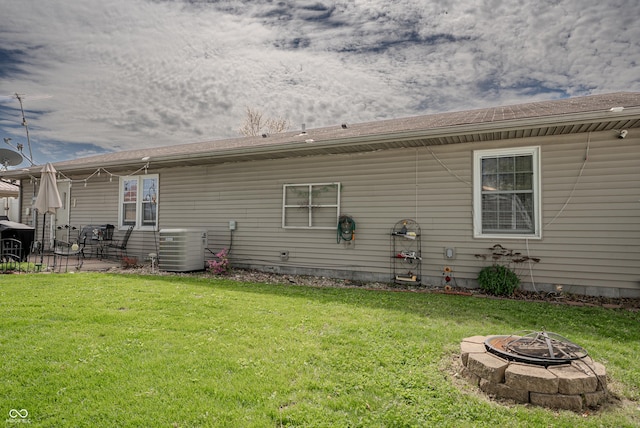 632 Woodside Ct, Seymour, IN 47274 - back of house with a lawn, central AC unit, and a fire pit
