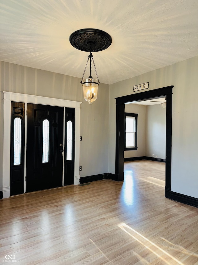 foyer with baseboards and light wood finished floors