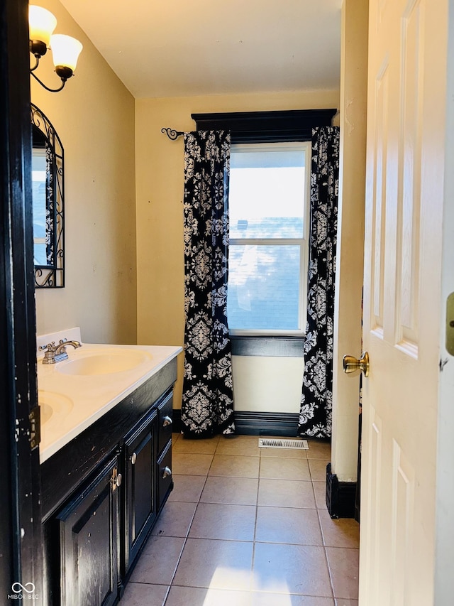 full bath with a sink, tile patterned flooring, double vanity, and visible vents