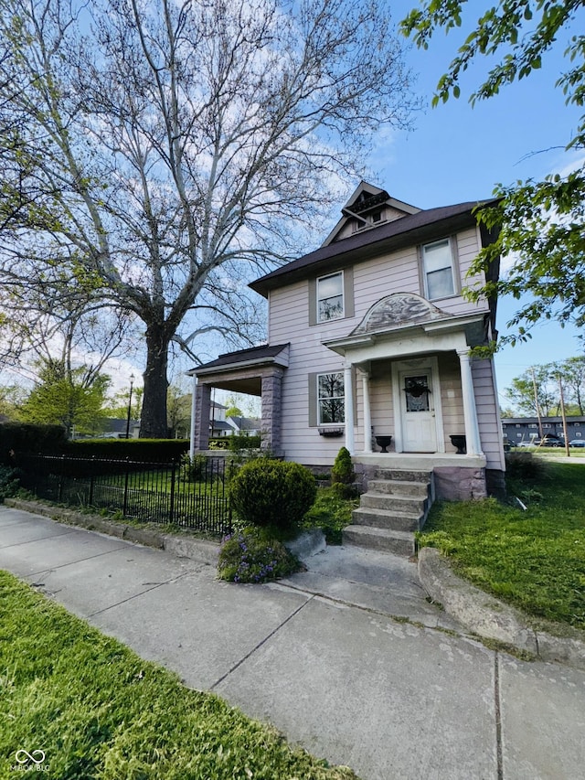 american foursquare style home featuring fence and a front yard