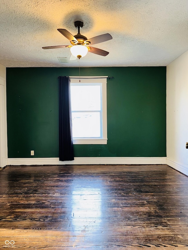 unfurnished room with baseboards, a ceiling fan, a textured ceiling, and wood finished floors