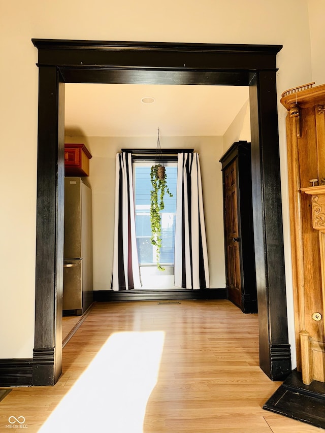 interior space featuring baseboards and light wood finished floors