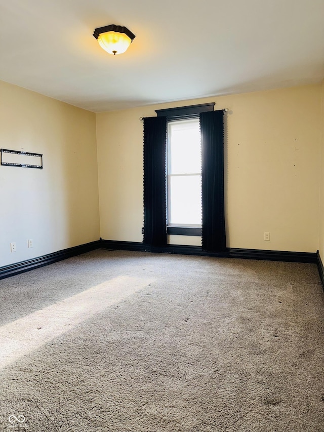 empty room with baseboards and carpet