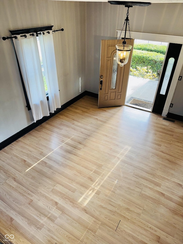 foyer featuring baseboards and light wood-style floors