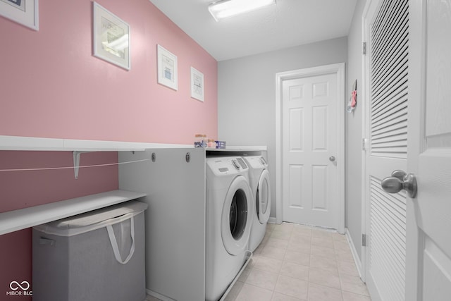 laundry room featuring laundry area, washer and clothes dryer, and light tile patterned flooring