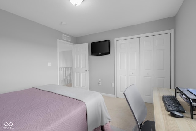 bedroom featuring visible vents, a closet, and light colored carpet