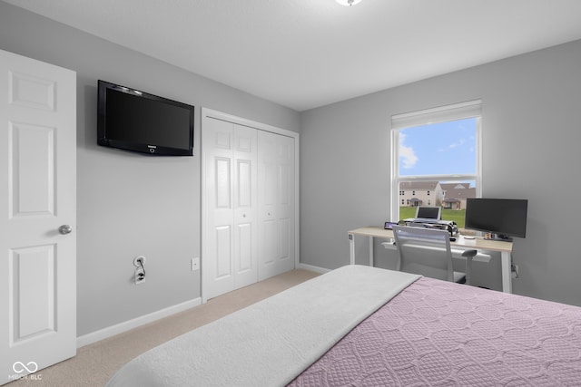 carpeted bedroom featuring baseboards and a closet