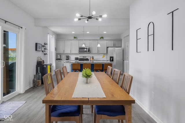 dining room with an inviting chandelier, baseboards, recessed lighting, and light wood-style flooring