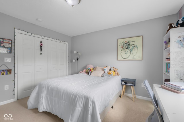 bedroom with baseboards, light carpet, and a closet