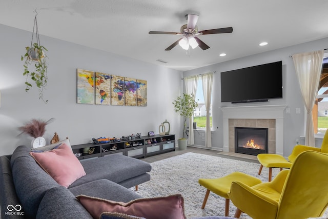 living room featuring ceiling fan, visible vents, wood finished floors, a tile fireplace, and recessed lighting
