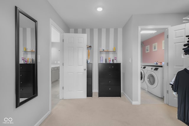 laundry room with laundry area, baseboards, washer and dryer, and light carpet