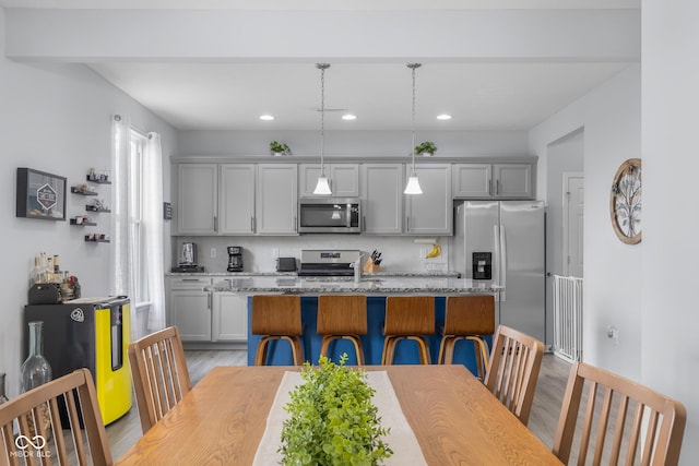 kitchen with gray cabinets, light wood-style flooring, a center island, stainless steel appliances, and recessed lighting