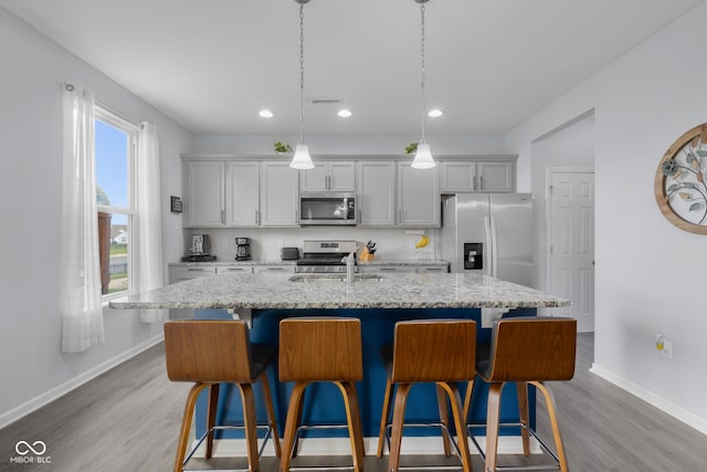 kitchen featuring baseboards, stainless steel appliances, and light wood finished floors