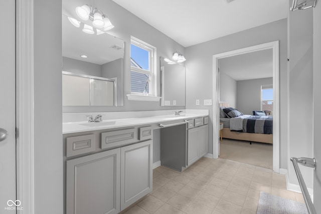 ensuite bathroom with double vanity, a sink, a wealth of natural light, and a shower stall
