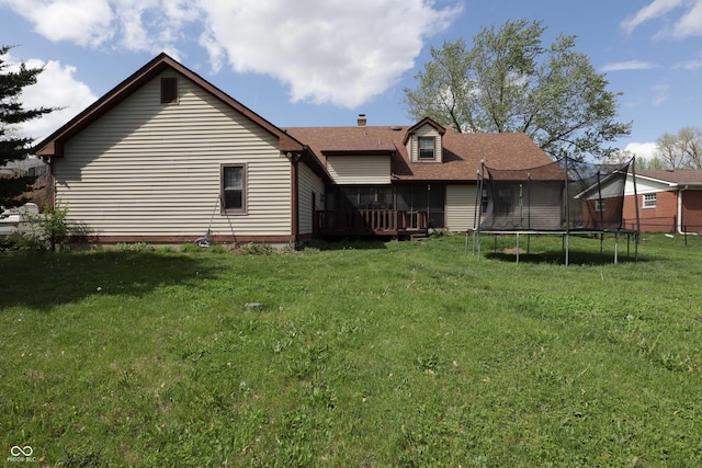 9903 E Raymond St, Indianapolis, IN 46239 - back of property featuring a wooden deck, a trampoline, a chimney, and a yard