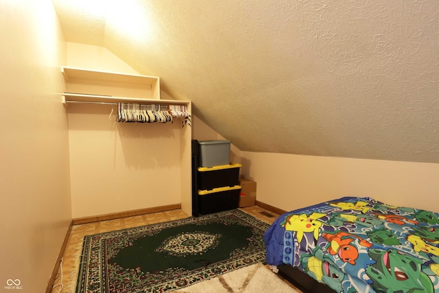 9903 E Raymond St, Indianapolis, IN 46239 - bedroom featuring a textured ceiling, baseboards, and lofted ceiling