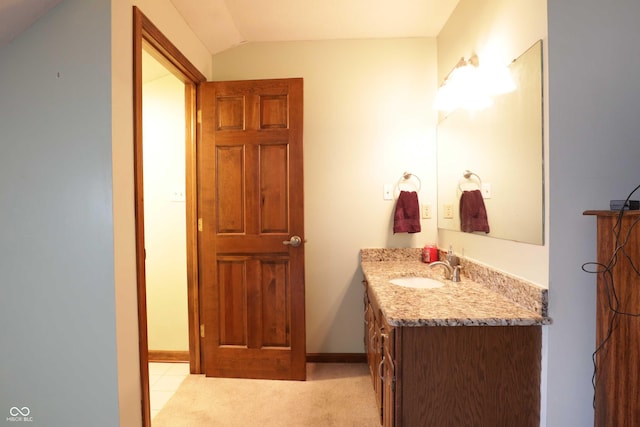 9903 E Raymond St, Indianapolis, IN 46239 - bathroom featuring baseboards, lofted ceiling, and vanity