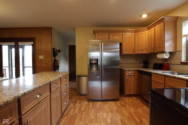 9903 E Raymond St, Indianapolis, IN 46239 - kitchen with backsplash, appliances with stainless steel finishes, brown cabinetry, and light wood finished floors