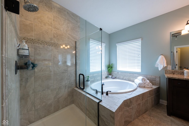 bathroom featuring a tile shower, a bath, and vanity