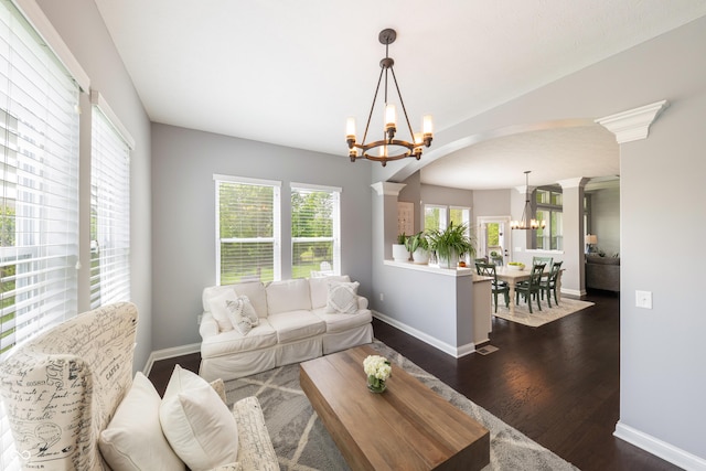 living area featuring a chandelier, arched walkways, plenty of natural light, and dark wood finished floors