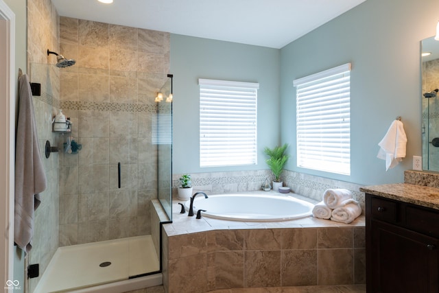 full bath featuring a garden tub, a stall shower, and vanity